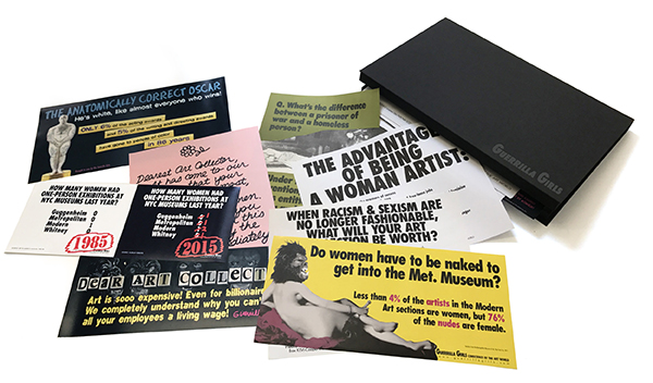 Bold, graphic prints with text are spread from a portfolio box.